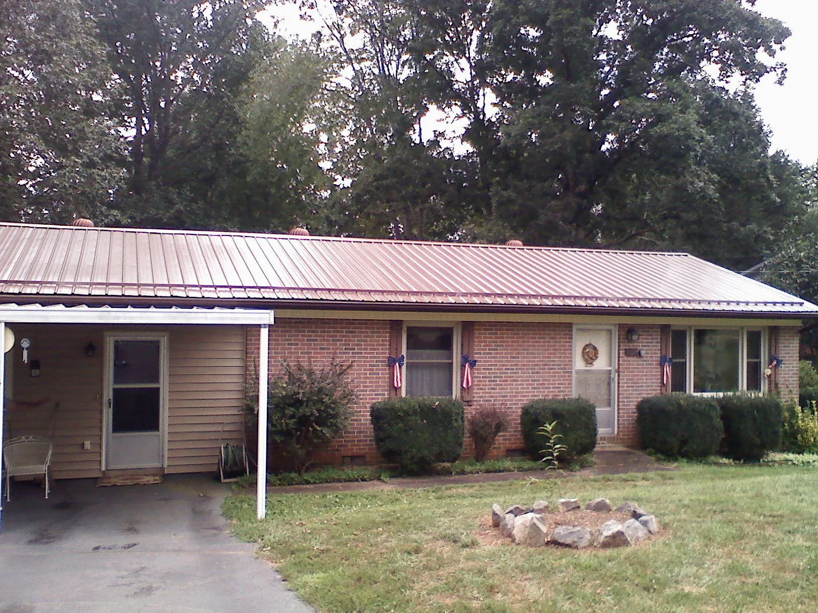 Bronze metal roof and carport on a brick ranch home — Roof Repair work by our crew in Danese